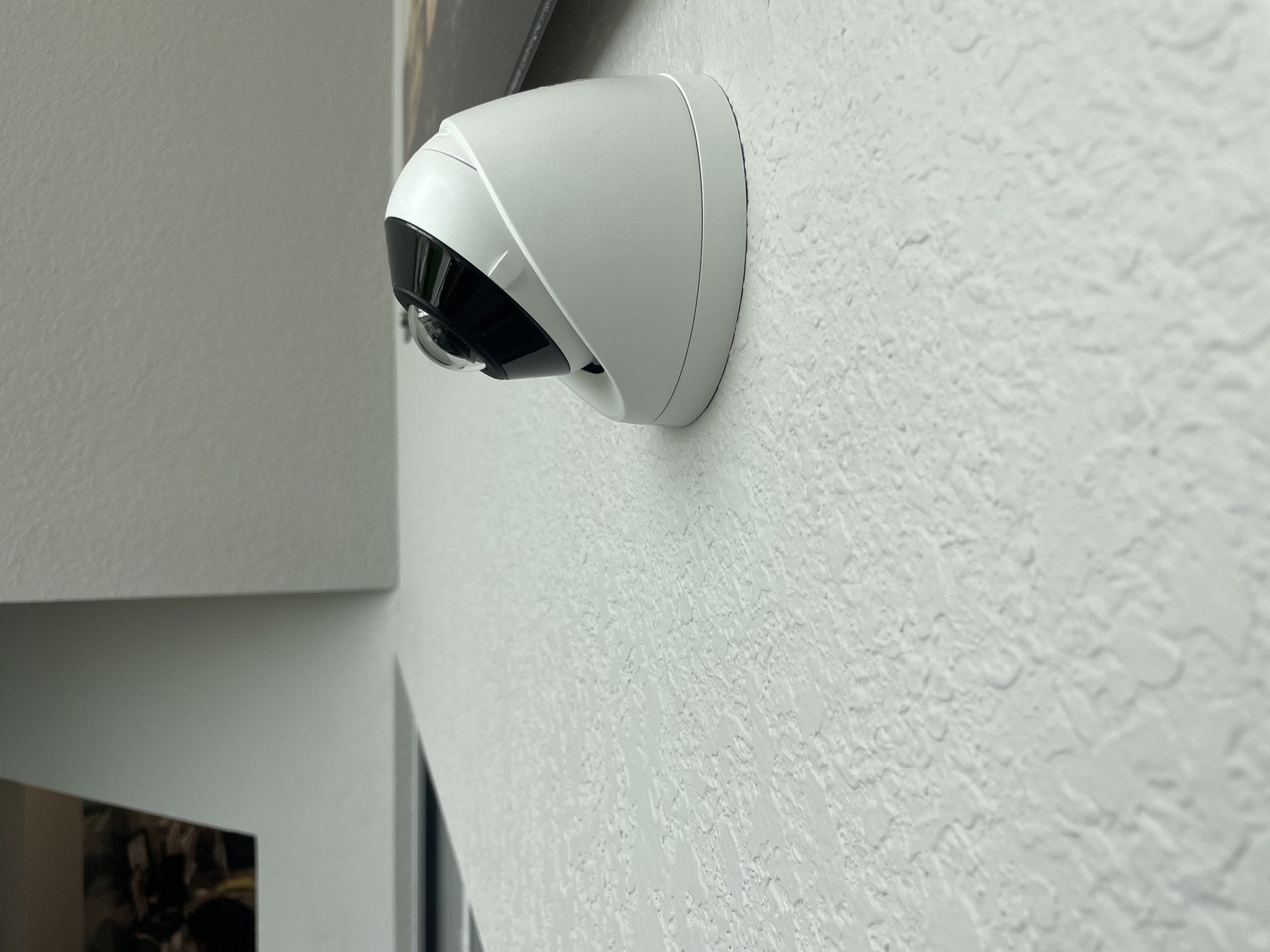 Close-up of an interior dome security camera cleanly mounted flush to the wall