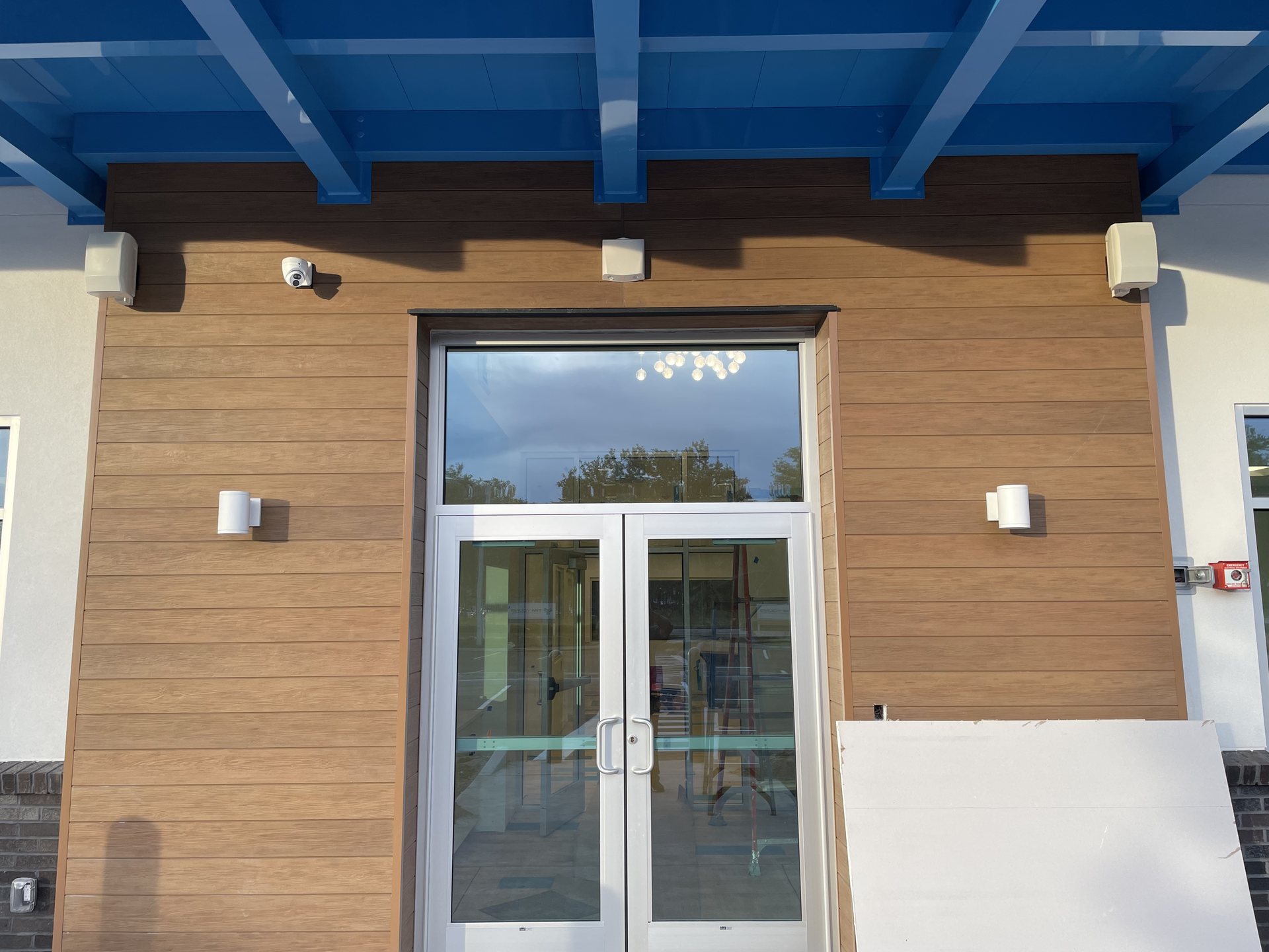 Covered school entry in Orlando, FL with a dome security camera, exterior speakers and architectural lighting installed by MonsterTech.com