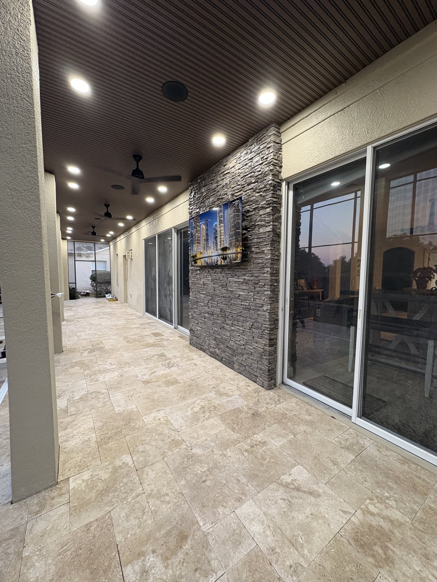 Covered lanai showing distributed outdoor audio placement and smart lighting layout