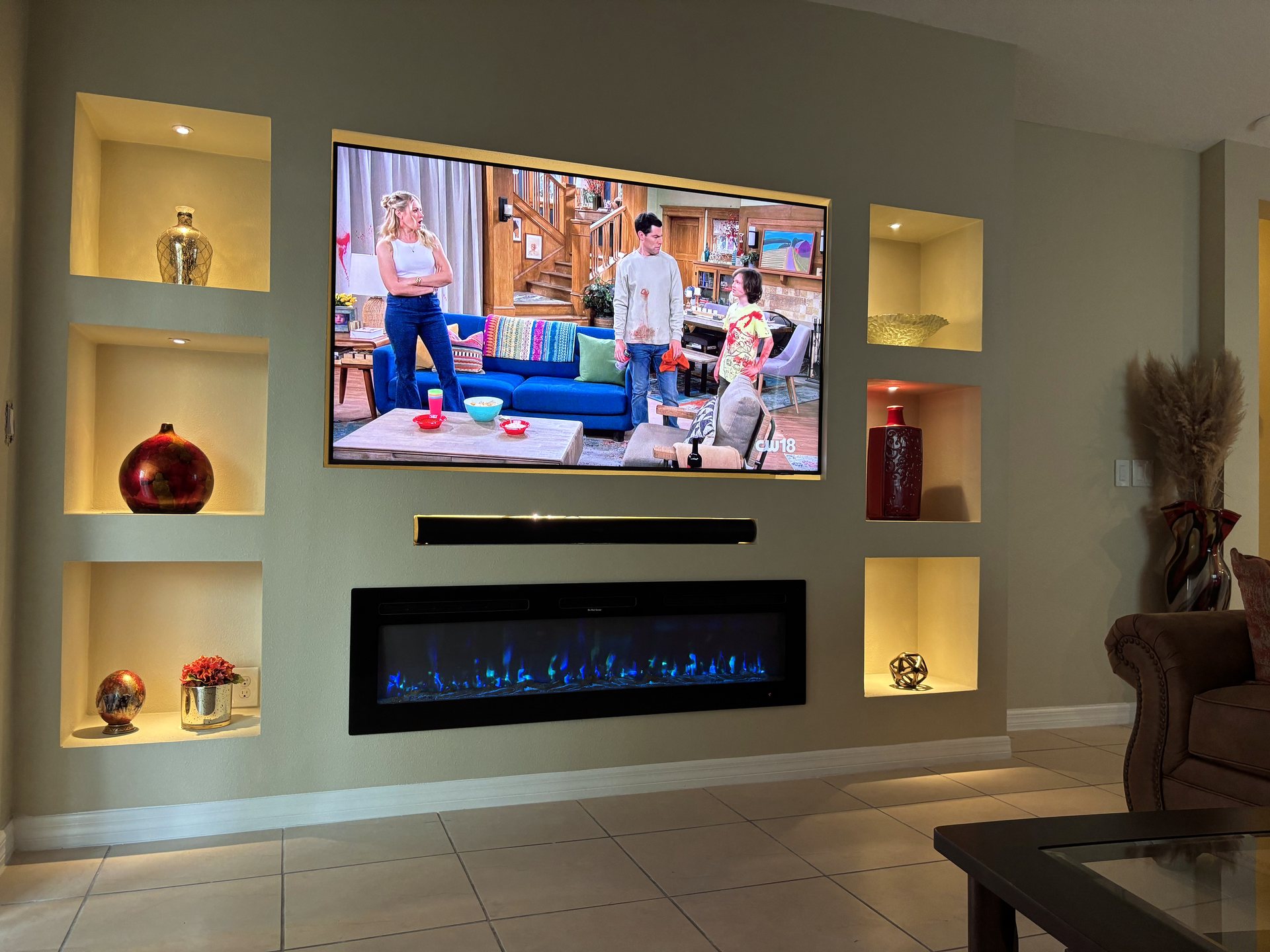 Custom entertainment wall in St. Cloud with mounted display, linear fireplace and lit display niches