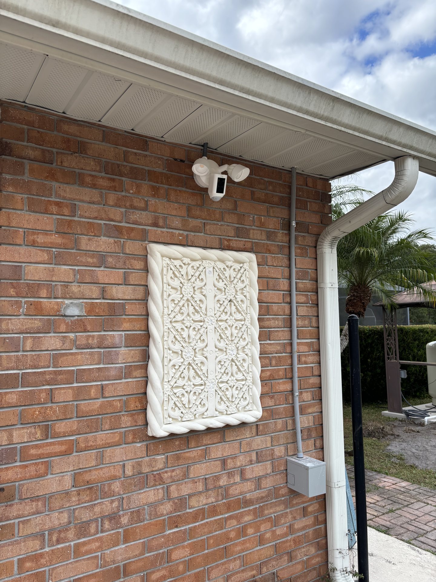 Exterior camera and neatly routed cabling installed on the brick wall of a residential home