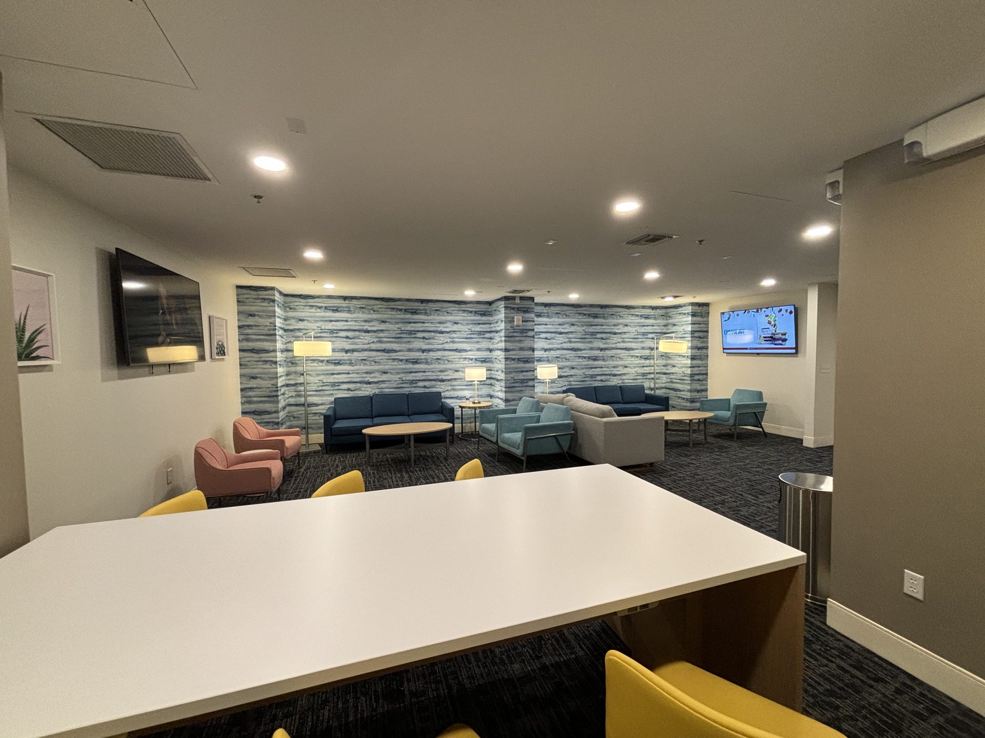 Completed Orlando lobby with two mounted displays, seating zones and Lutron lighting scenes