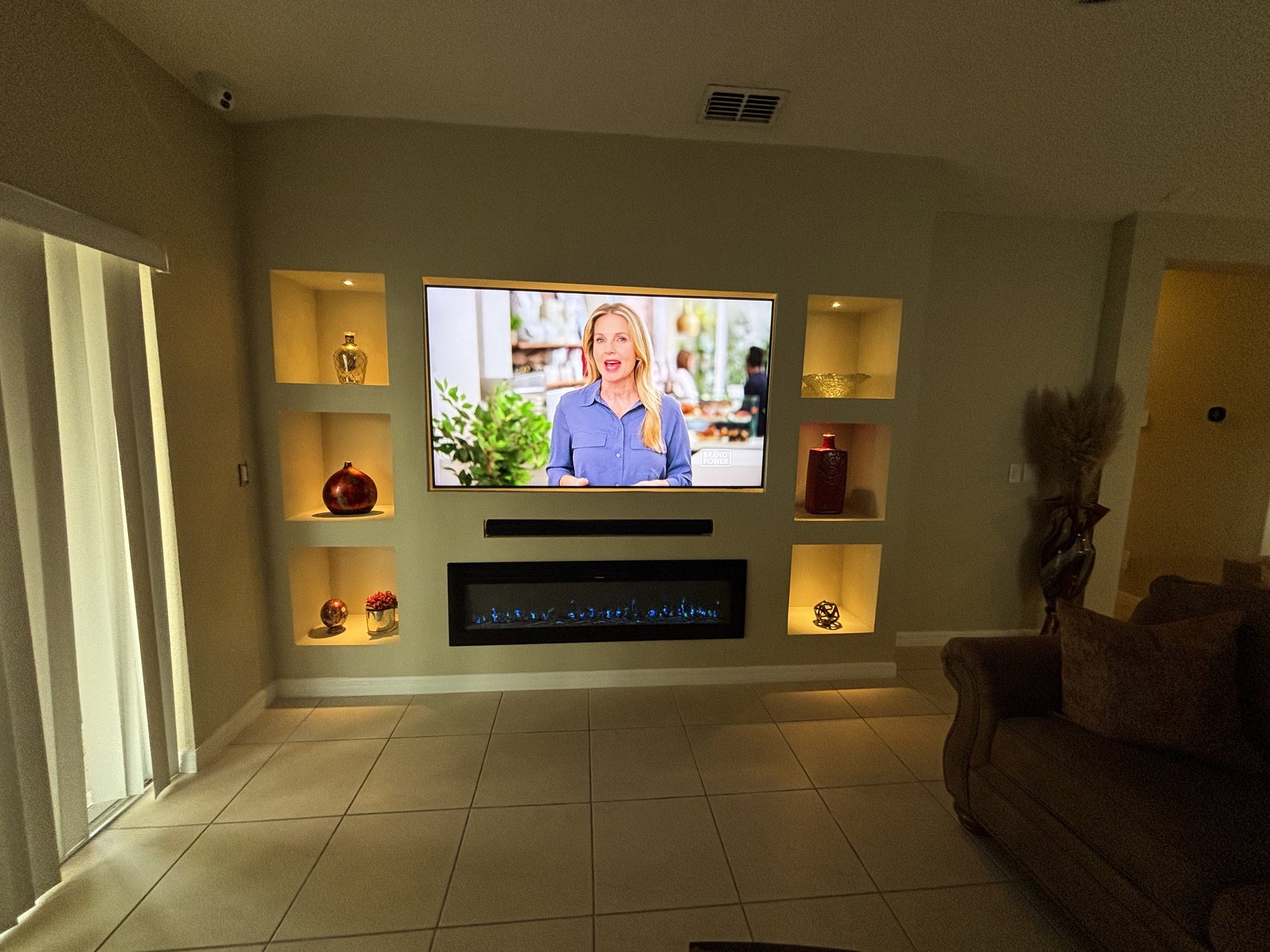 Entertainment wall with concealed AV wiring, soundbar and smart-controlled accent lighting