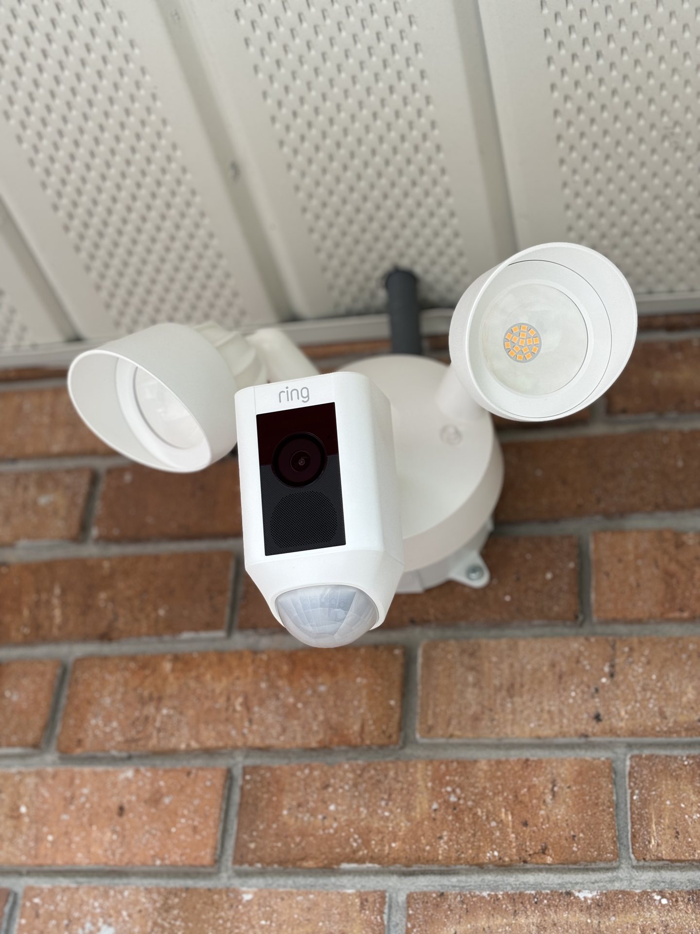 Ring floodlight camera installed under the eave of a Davenport home covering the entry approach
