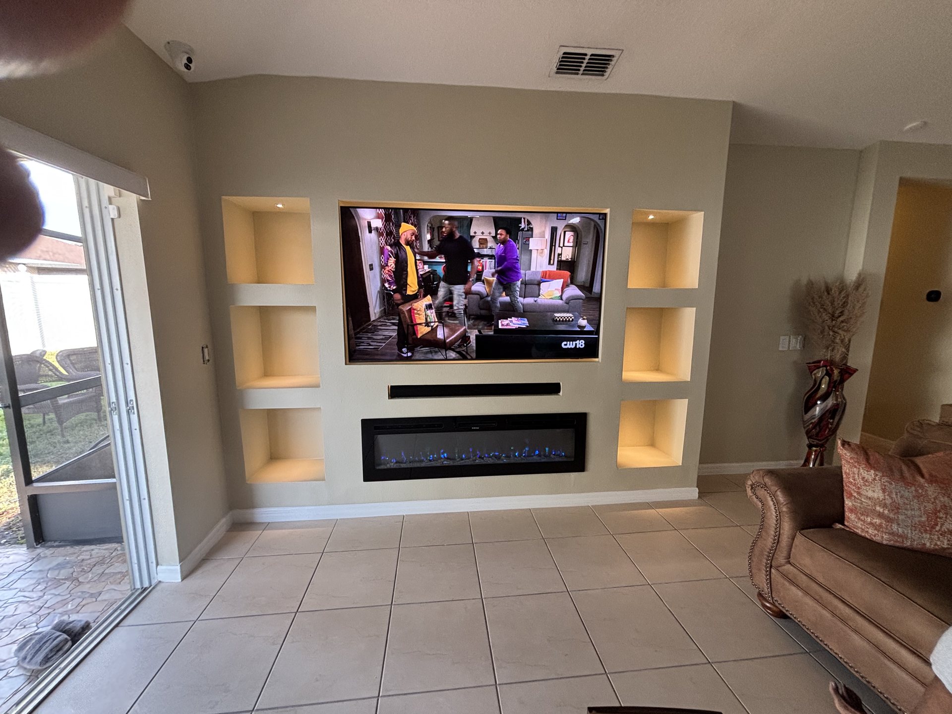 Living space view of the built-in entertainment wall with integrated display and lighting scenes