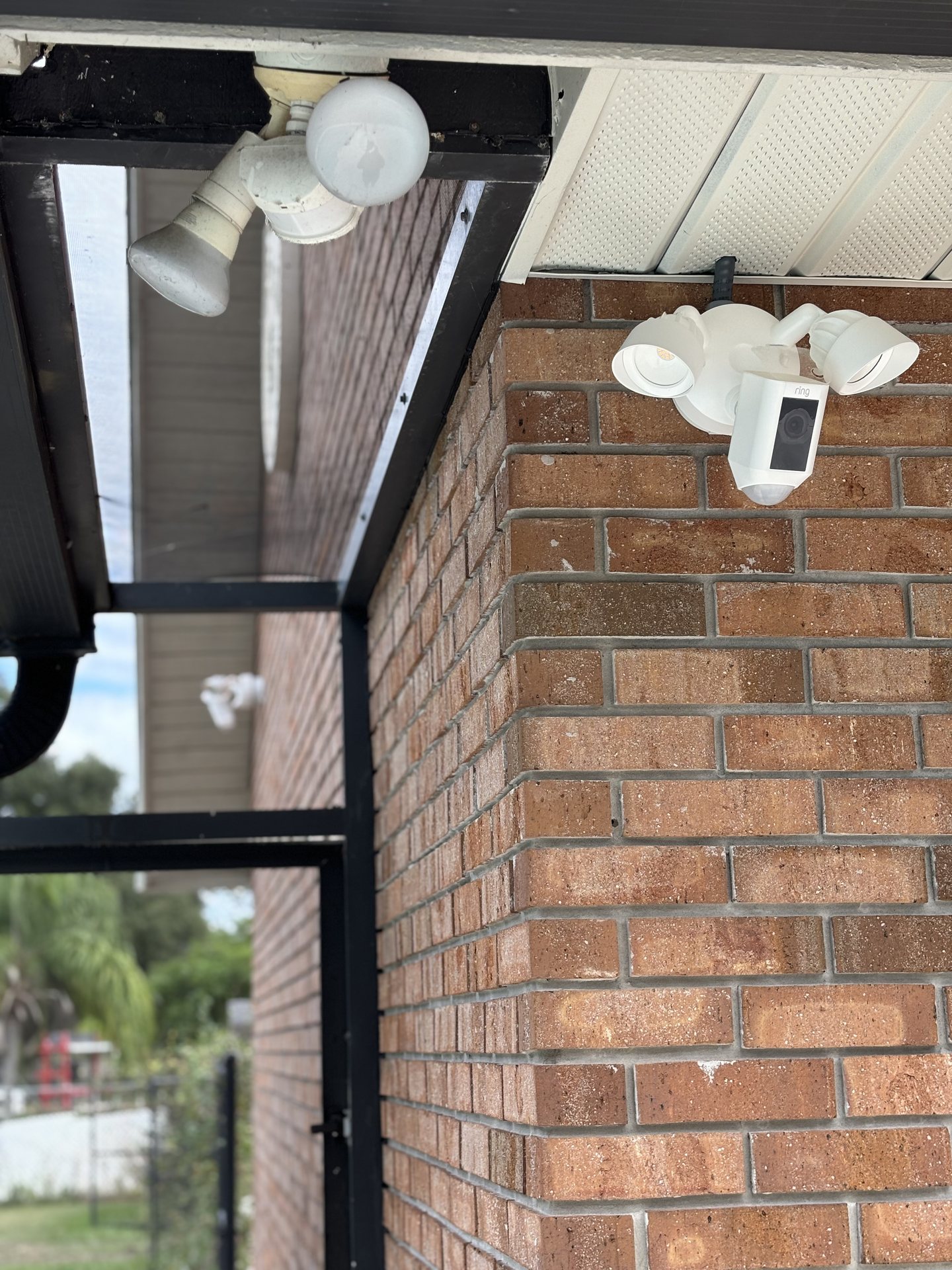 Floodlight camera mounted at a screened lanai corner covering the rear yard